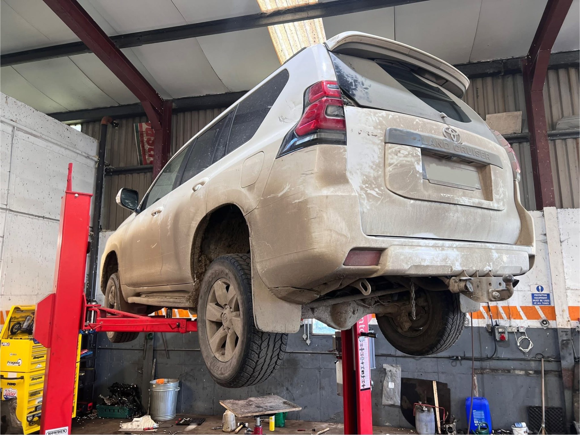 Toyota Land Cruiser raised on the lift for underside work