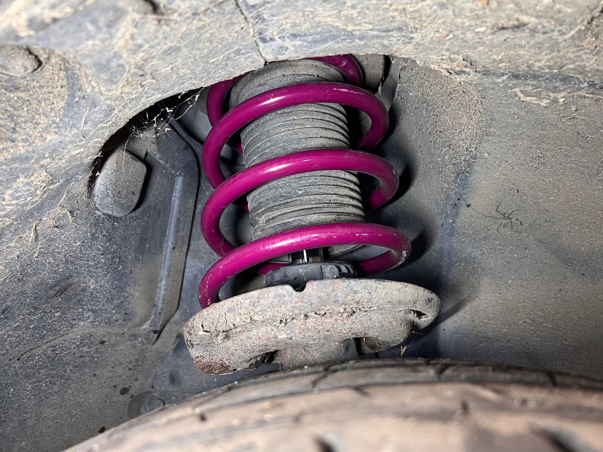 Freshly fitted purple coil spring on a car suspension